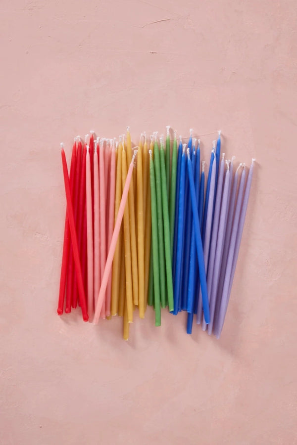 Knot & Bow tall assorted beeswax candles laid out in rainbow gradation