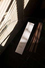 Aviles Stick Incense by Yield with its white packaging and independent sticks in a dramatically lit room.