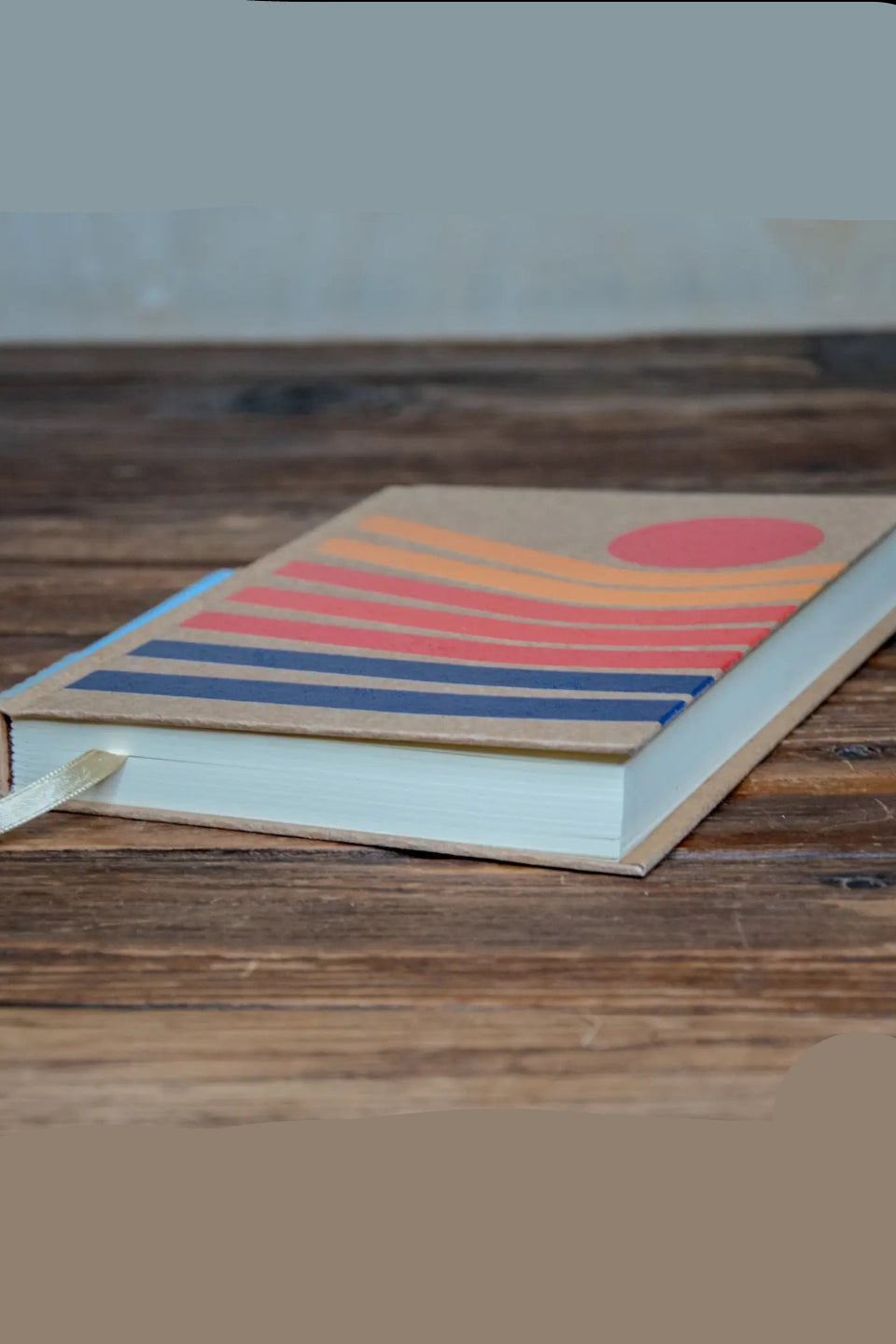 Notebook with a colorful design on a wooden surface ©Glum Lot Press