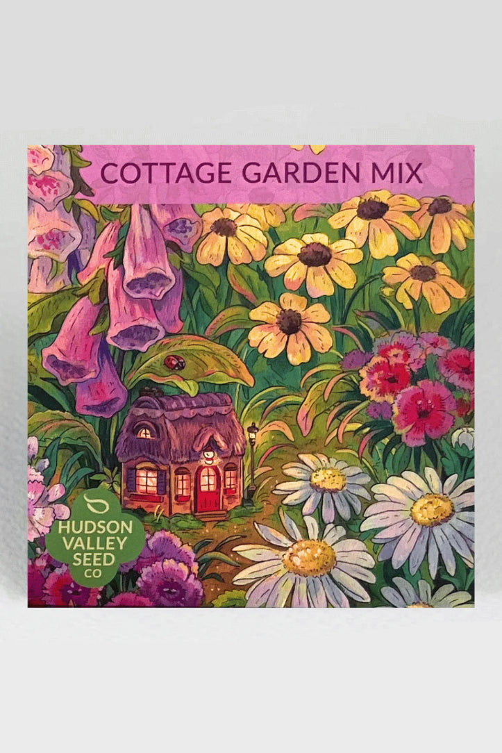 Cottage Garden Mix seed packet with colorful flowers and a small house illustration on a pink background. ©Hudon Valley Seed Co.