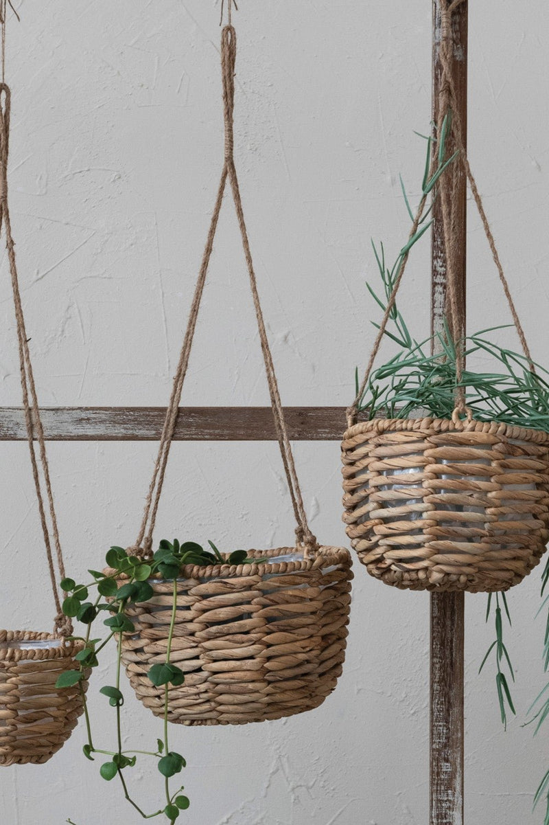 Various sized Water Hyacinth hanging baskets with plants inside.