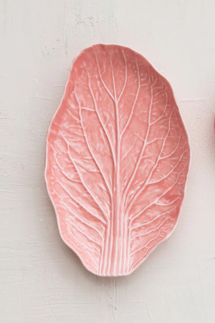 A pink leaf-shaped ceramic plate on a white surface ©Creative Co-Op