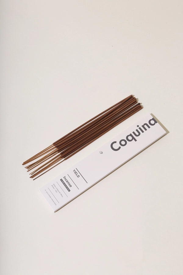 Coquina Stick Incense by Yield stick laying down separately in a group outside of the packaging next to them.