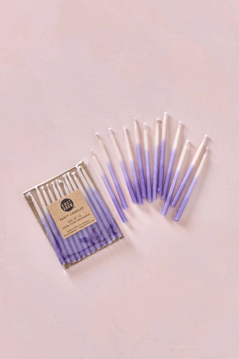 Knot & Bow Short Ombre Violet beeswax candles one out of its pack and one set in its packaging.