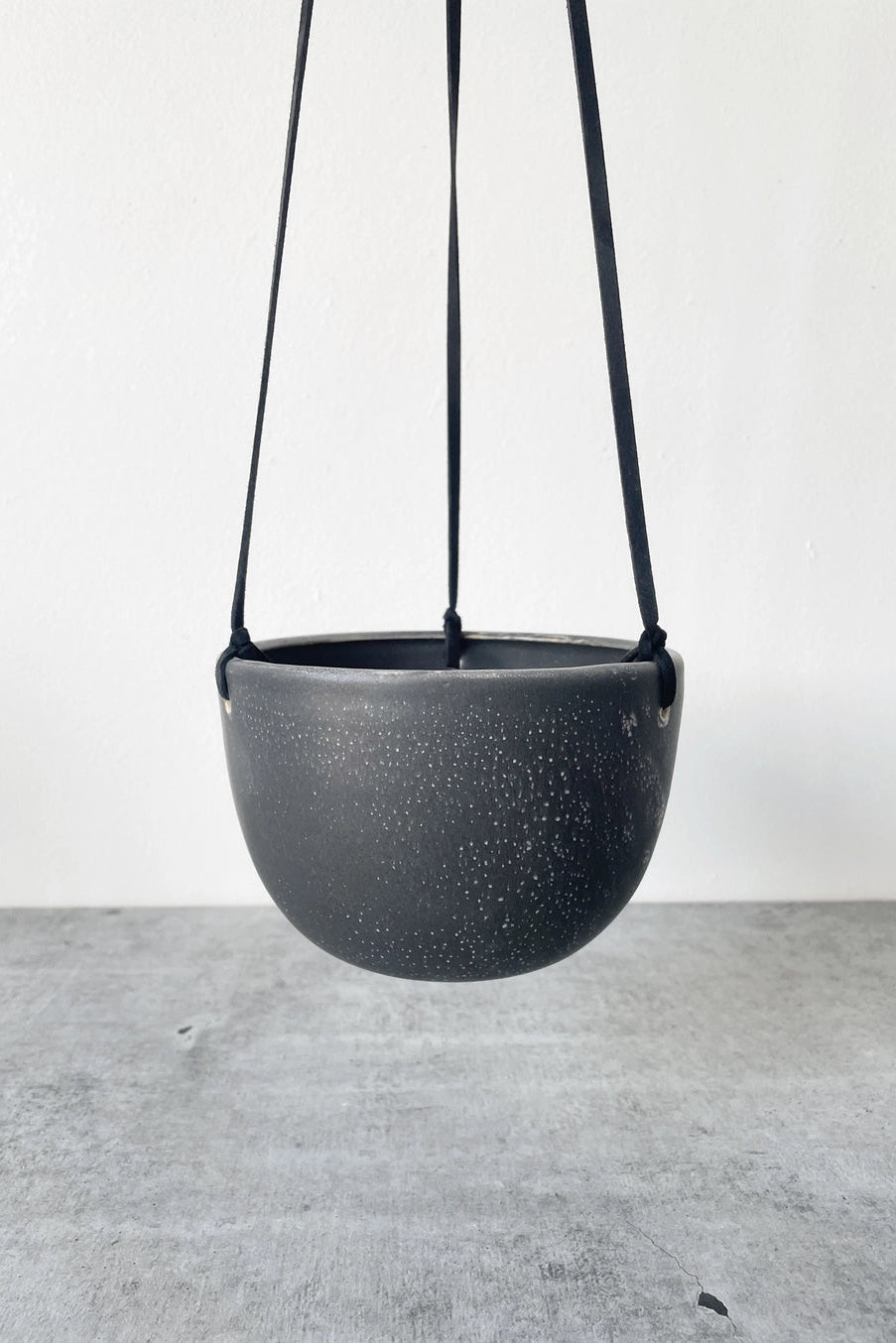 black speckle hanging planter with black leather on a white background ©Little Fire Ceramic