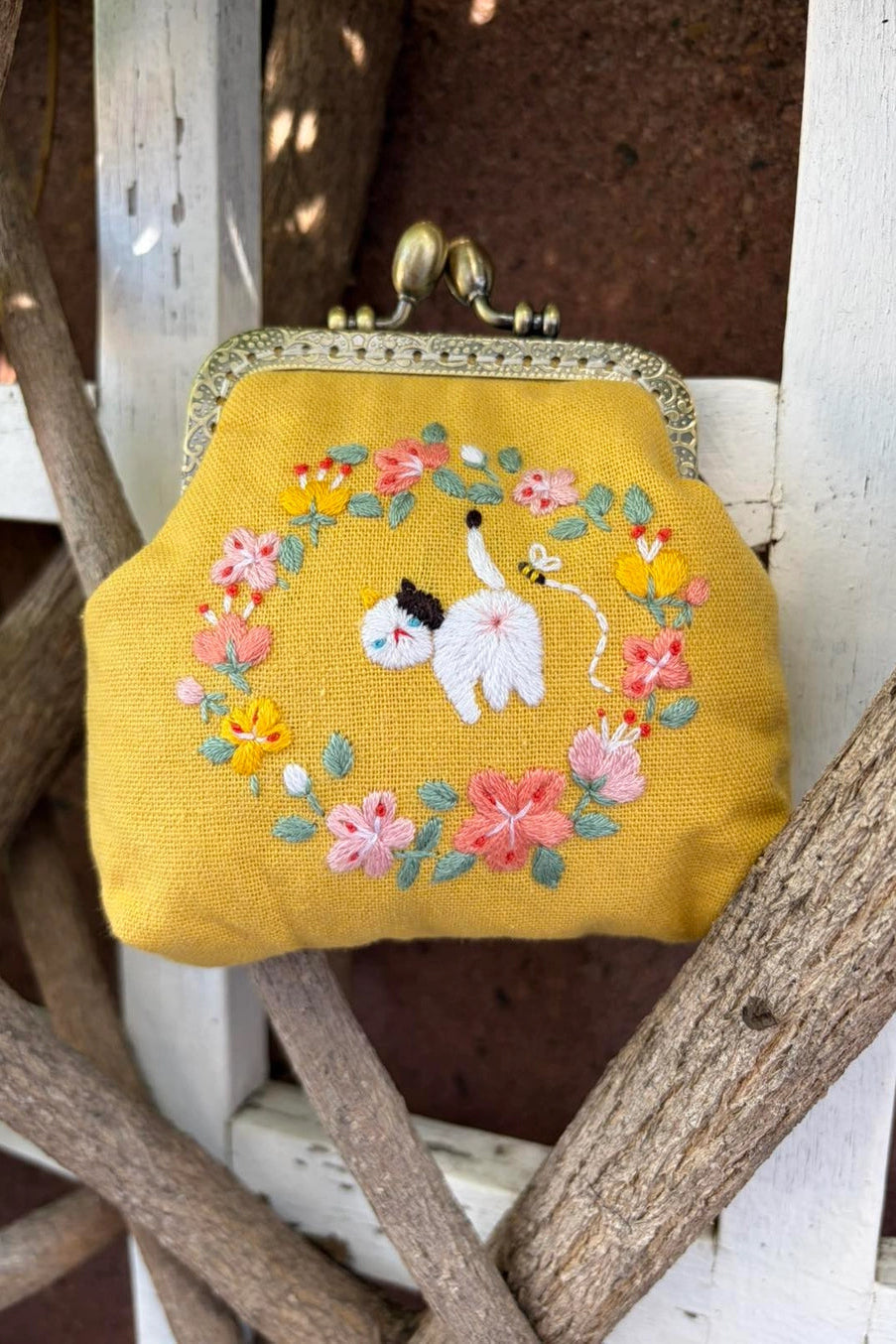 Cat Embroidered Coin Purse with floral design and cat illustration on a wooden surface ©Quince Fables