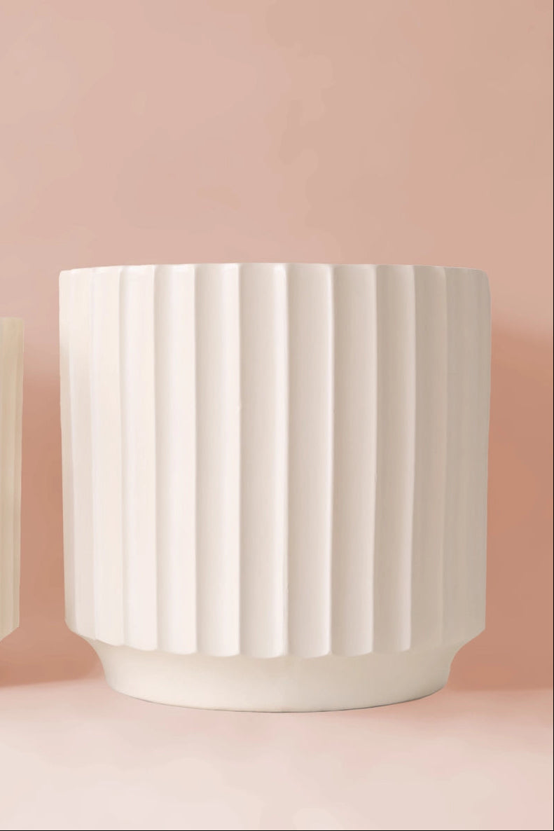 White Monroe Planter by Jungle Club showing the vertical ridges against a light pink wall.  ©Jungle Club