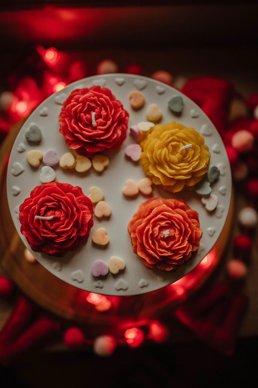 Decorative cake with red, yellow, and orange flowers on a blurred red background ©The Holten Homestead