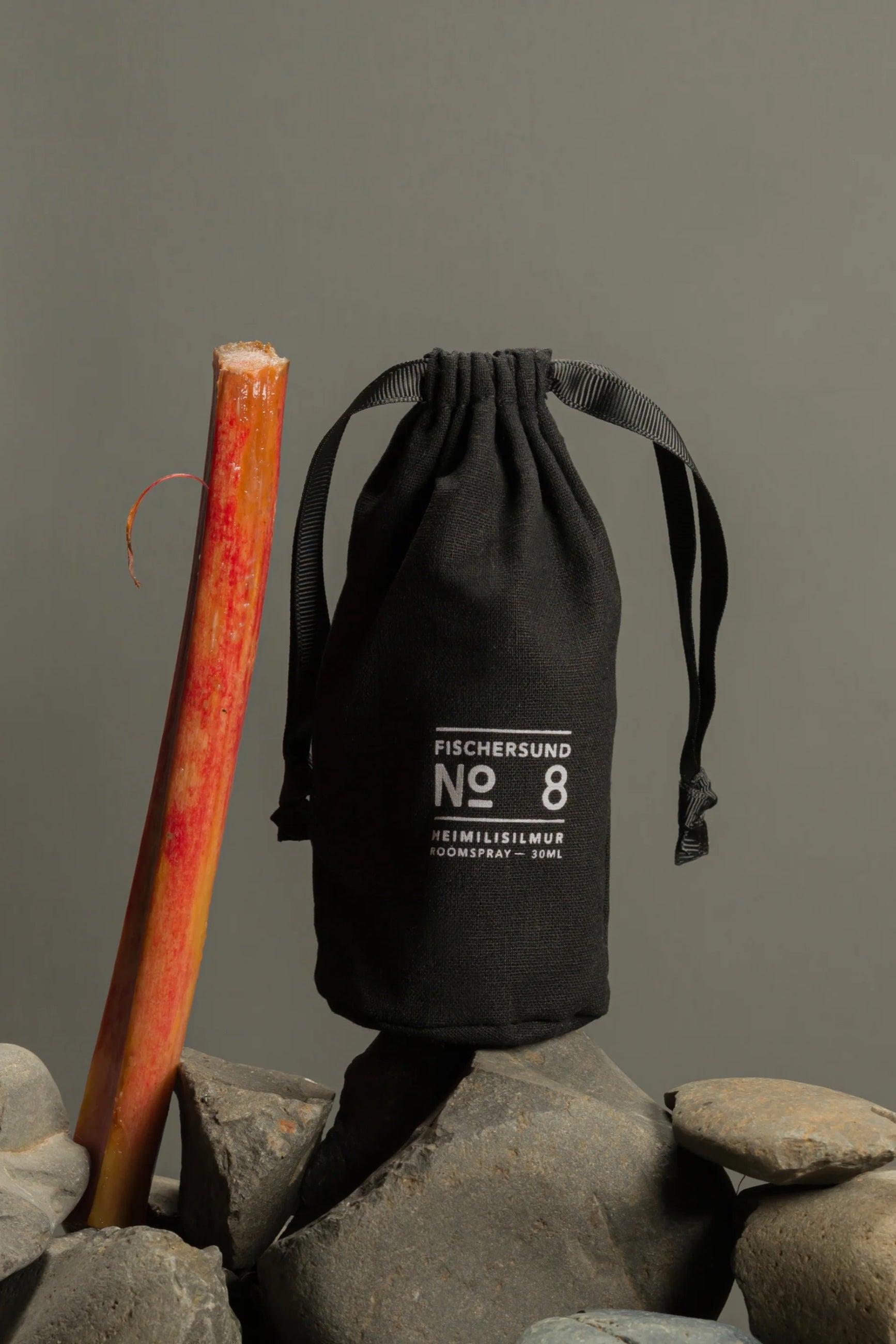 Black drawstring bag with 'Fischersund No. 8' branding on rocks against a gray background ©Fischersund