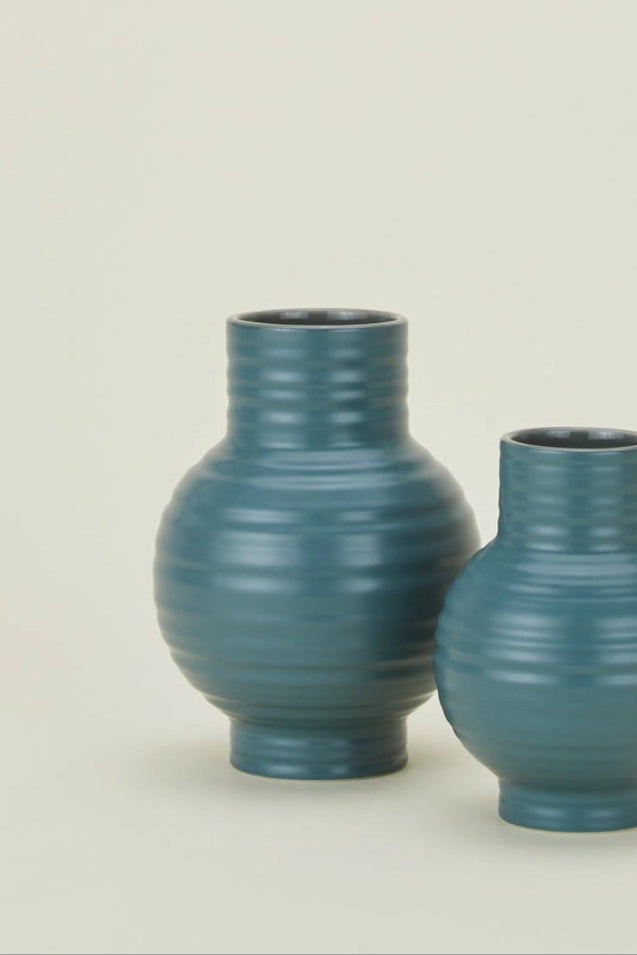 Hawkins New York Essential Peacock Ceramic Vases with ribbed texture on a beige background ©Hawkins New York