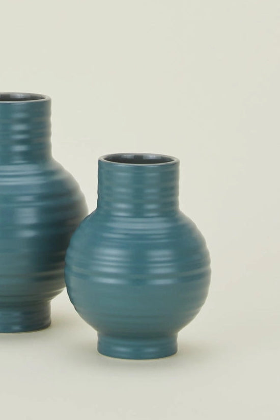 Hawkins New York Essential Peacock Ceramic Vases with ribbed texture on a beige background ©Hawkins New York