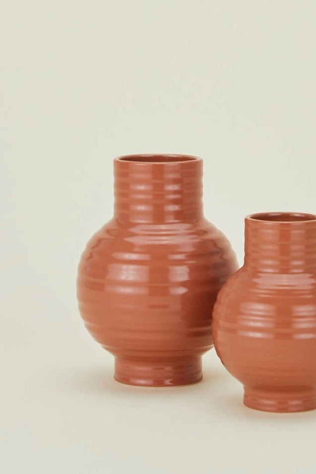 Two Hawkins New York terracotta Essential vases on a beige background ©Hawkins New York