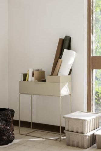 The Cashmere Plant Box w/ stand by Ferm Living shown in a lifestyle shot with books and rolled papers inside. 