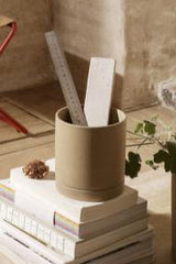 Ferm Living Medium Sand Sekki Pot in a lifestyles hot with a ruler and a piece of white stock inside on top of books