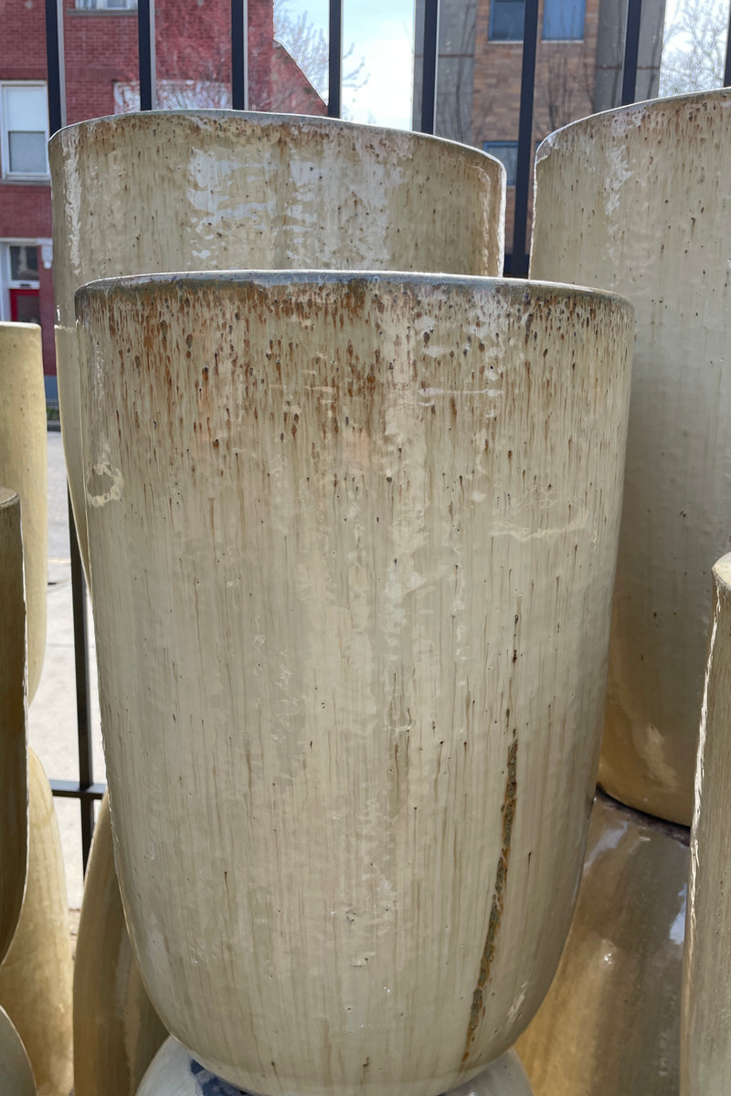 Sand Crucible planters stacked at Sprout Home in front of a fence. 