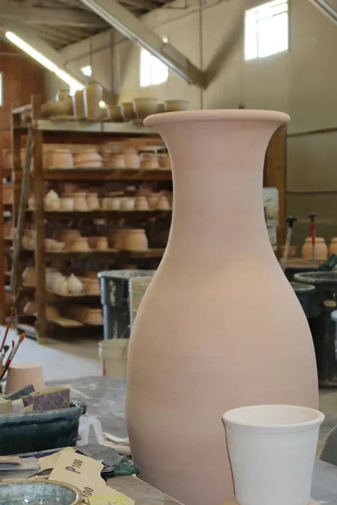 Large ceramic bisque vase in the Bruning Pottery workshop setting with tools and materials around ©Bruning Pottery