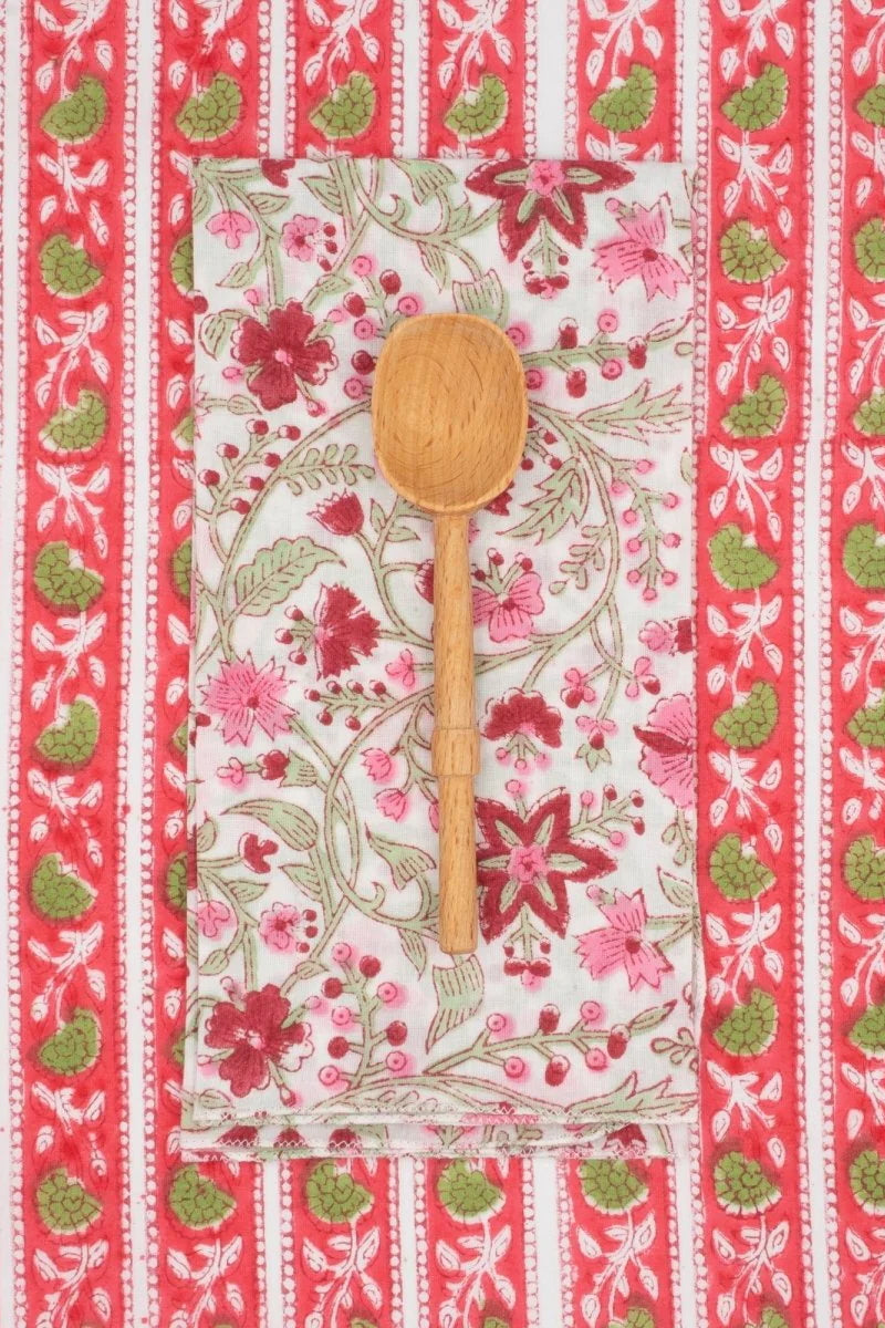 Cotton Napkins Chrysantheme Brigitte  sitting on a pink floral striped cloth with a wooden spoon ©Suzette a Table