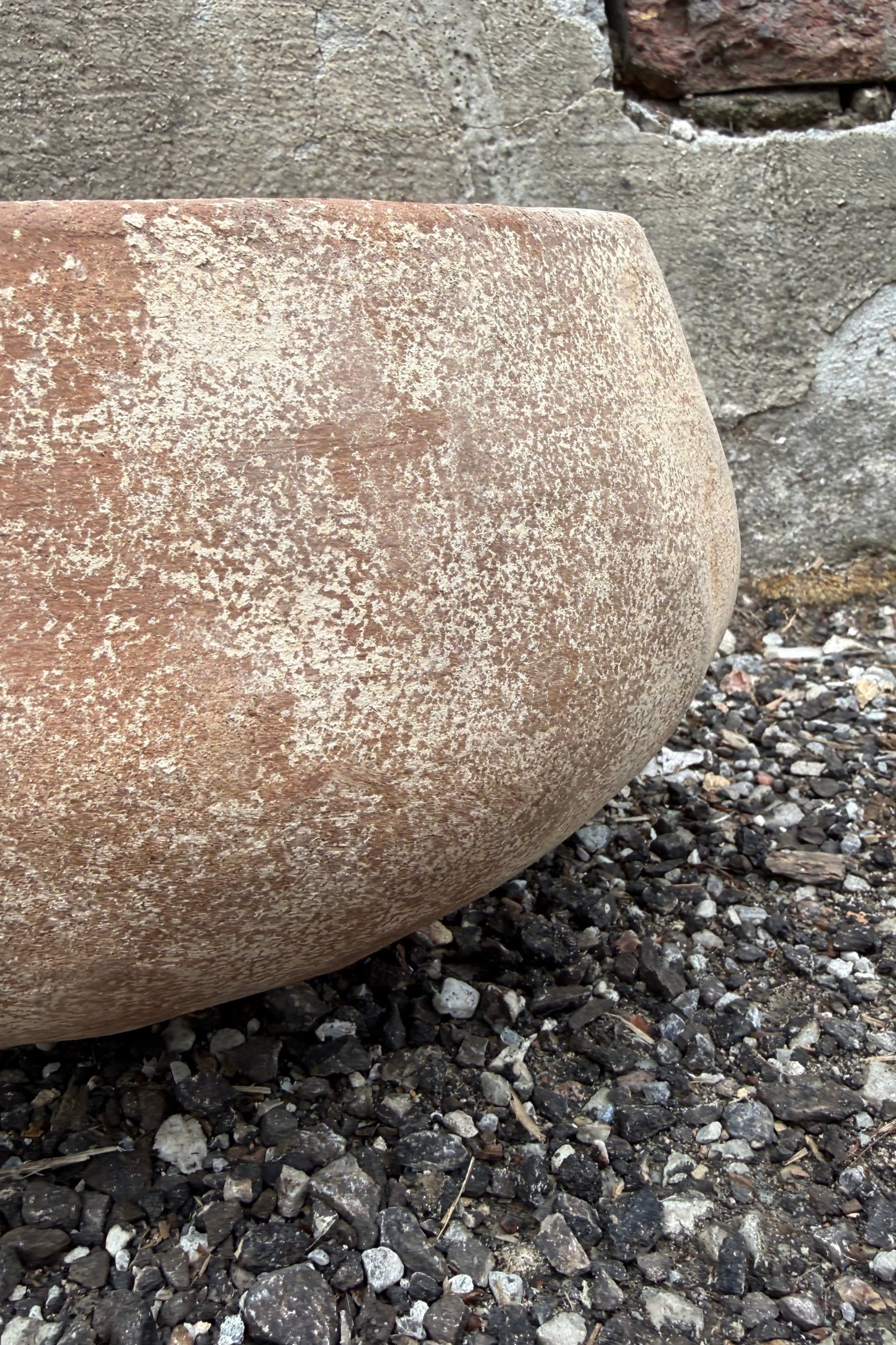 Close-up of a textured Sansui Tapered Vietnamese Rustic Bowl Medium on a gravel surface with a blurred background ©Sprout Home