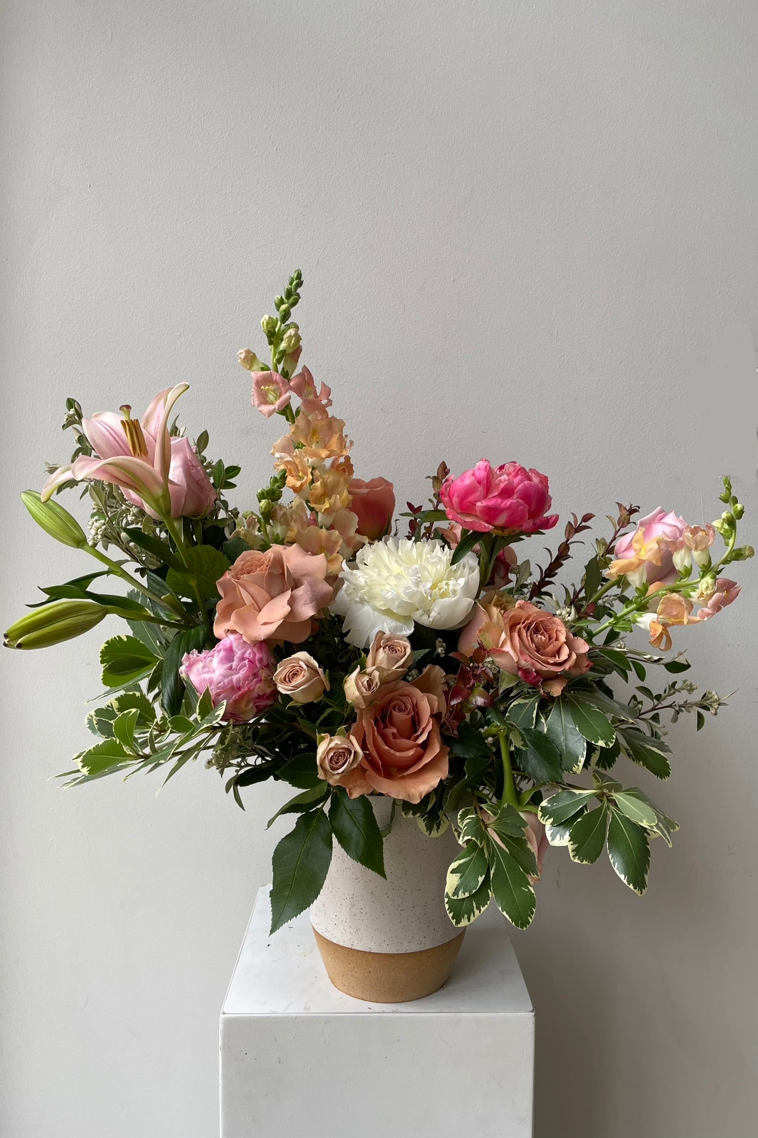 Sprout Home Dusk arrangement in a white speckled vase and flesh tone floral the beginning of June. #size_$160