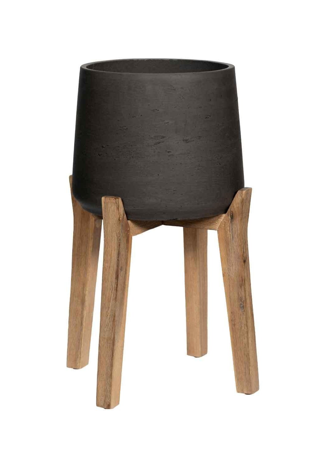 Black Washed Patt Pot with High Feet by Pottery Pots against a white wall. 