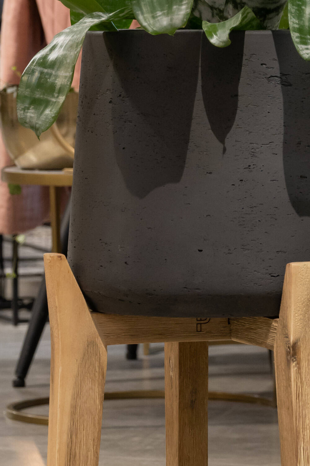 Black Washed Patt Pot with High Feet by Pottery Pots  detail showing the base of the planter and the top of the wooden feet legs.