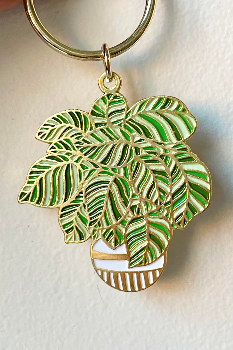 The Plant keychain is held against a white backdrop.