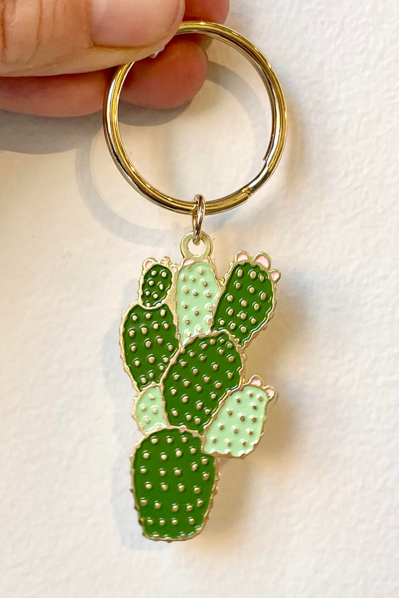 A hand holds the Cactus Keychain against a white backdrop.