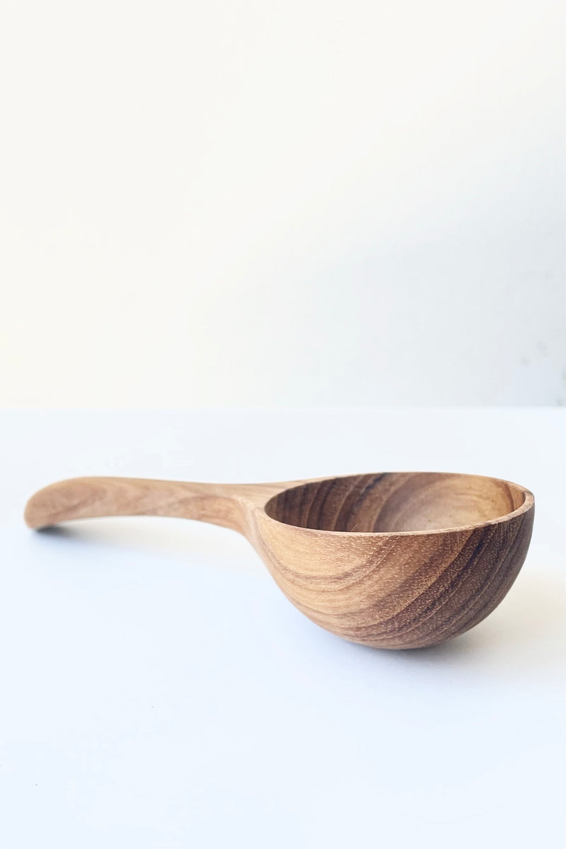 A side view of the handcrafted Teak Scoop against a white backdrop