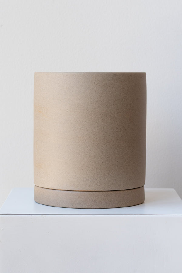 Sand large Sekki plant pot by Ferm Living on a white pedestal in front of a white background