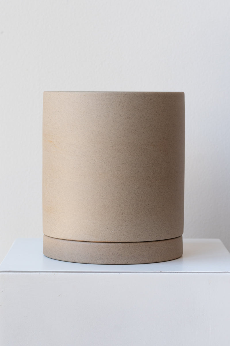 Sand large Sekki plant pot by Ferm Living on a white pedestal in front of a white background