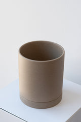Sand medium Sekki plant pot by Ferm Living on a white pedestal in front of a white background