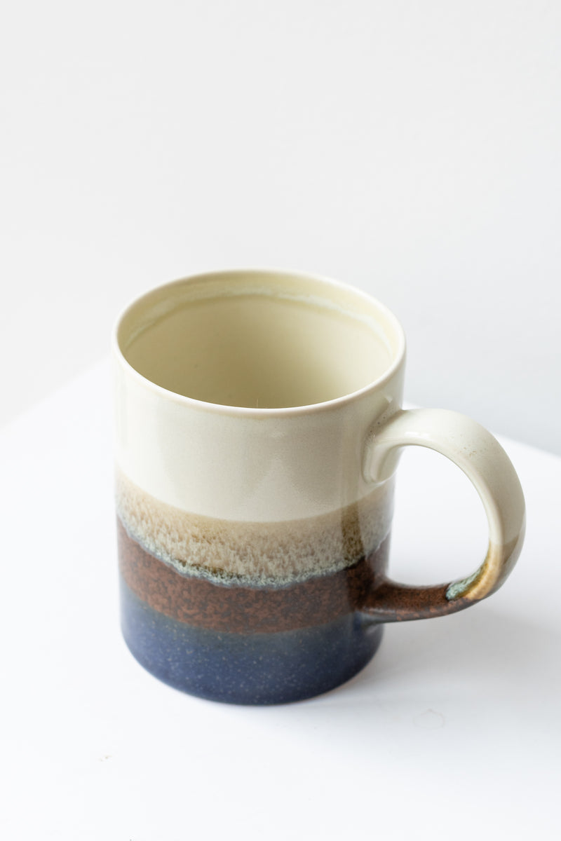 Cafe Con Panna Mug by Kotobuki sits on a white surface in a white room
