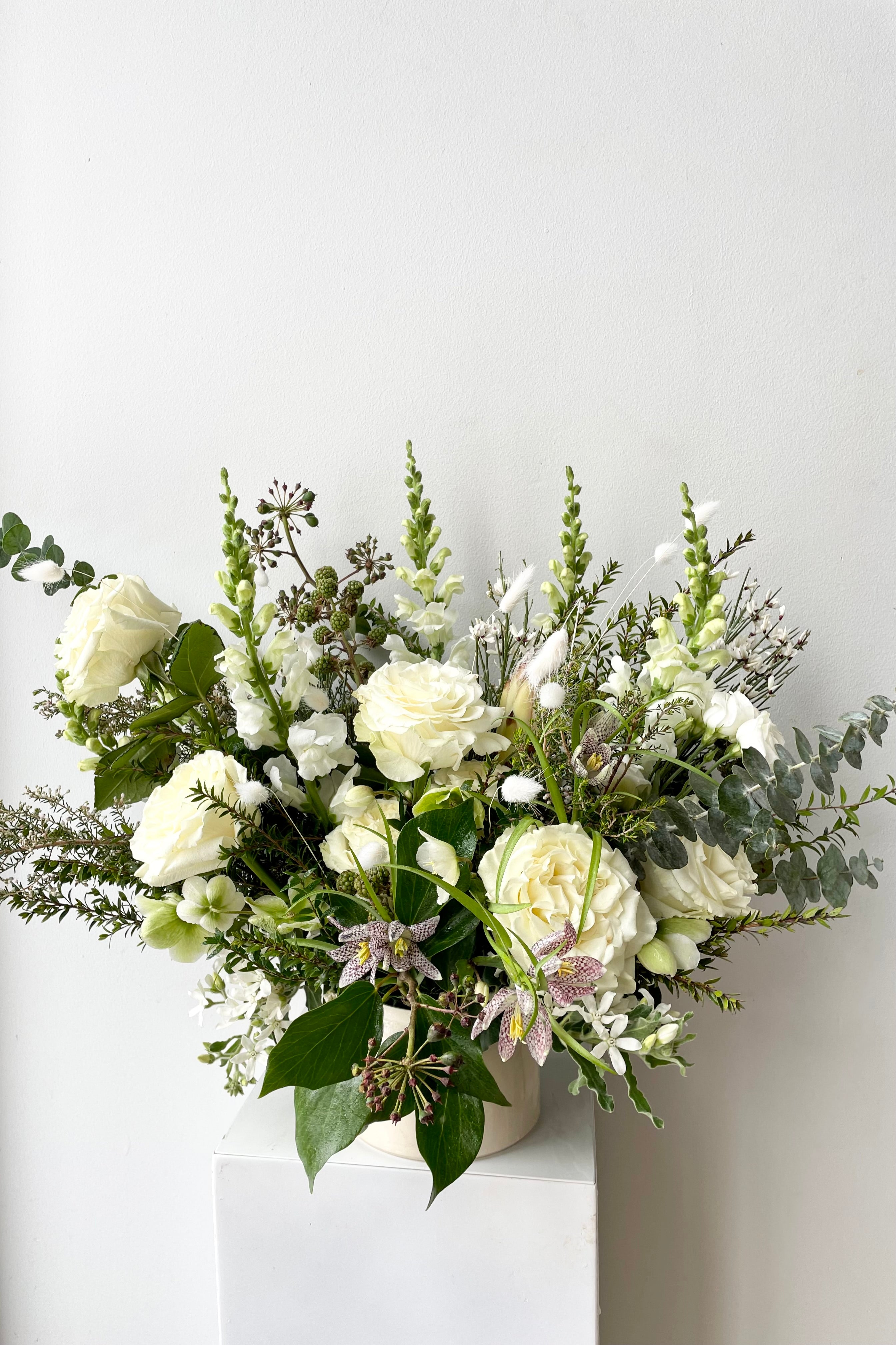 An example of Floral Arrangement Bleached by Sprout Home in Chicago. The arrangement uses primarily white flowers with green foliage. #size_$160