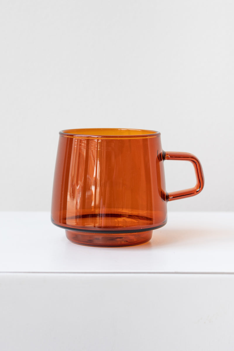 Kinto sepia glass amber mug on white surface in white room