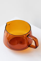 Kinto sepia glass amber jug on white surface in white room