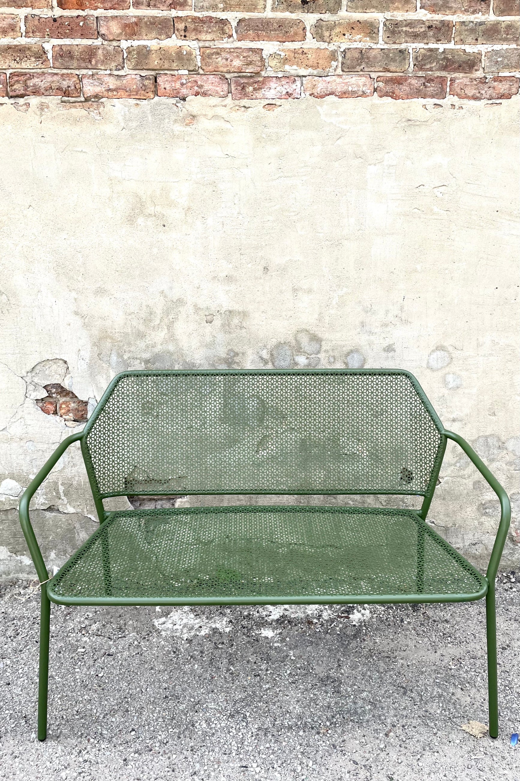 A frontal view of the Martini Iron Garden Bench in Moss against a concrete backdrop  ©Sprout Home