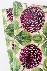 detail  of purple dahlia printed linen tablecloth draped over table