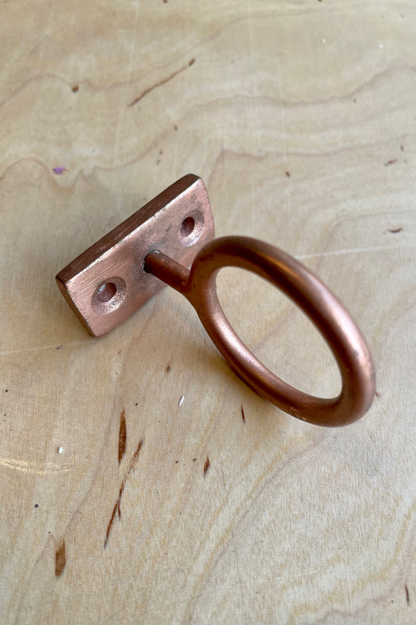 The Copper Bijou hanging ring on a wood shelf at Sprout Home.