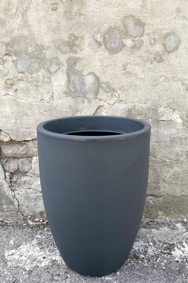 A frontal view of the 20" Porto Planter in Grigio against a concrete backdrop