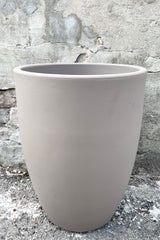 A frontal view of the 20" Porto Planter in Taupe against a concrete backdrop