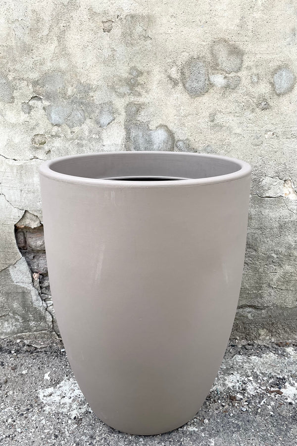 A frontal view of the 24" Porto Planter in Taupe against a concrete backdrop
