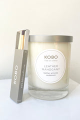 Kobo Candle leather mahogany out of its packaging alongside a box of Kobo matches against a white backdrop