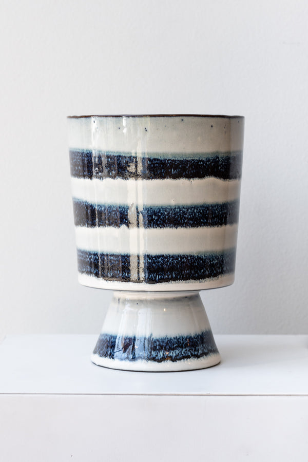 Striped blue and white glazed Toku chalice vase by Homart on a white surface in a white room