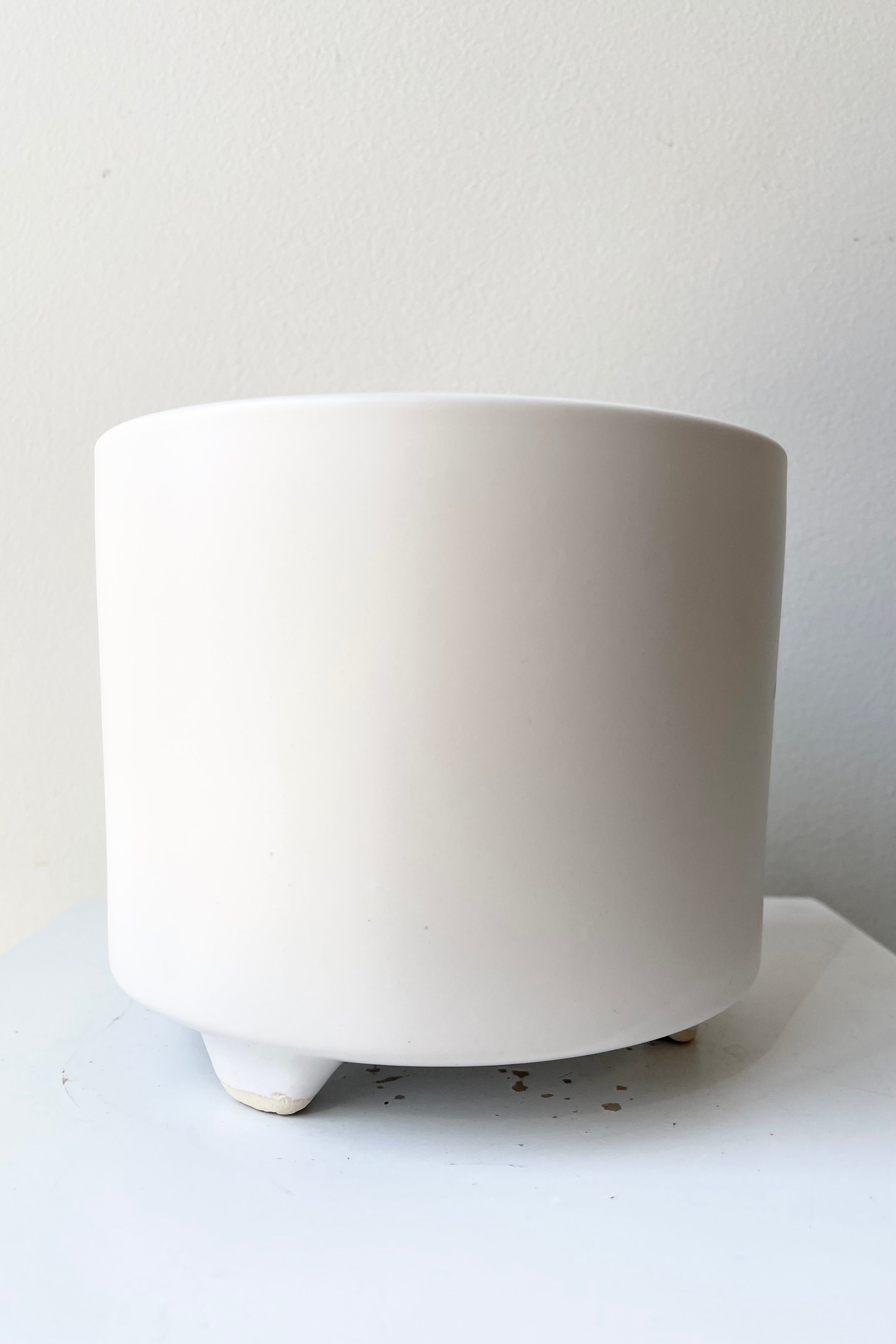 The white Simon footed pot small against a white wall at Sprout Home.