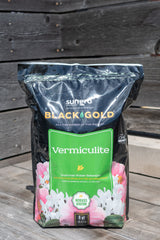A bag of Black Gold vermiculite in an 8quart size against a wood fence at Sprout Home.