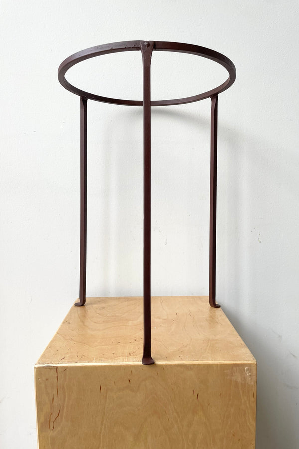 Iron Plant Stand Low 12" D x 17" H against a white wall