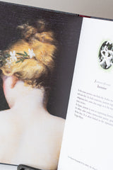 Inside of Jean-Michel Othoniel: The Secret Language of Flowers. Open to a page with information about Jasmine and a painting of a woman with jasmine in her hair
