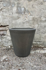 The 14" old bronze madison planter against a cement wall. 