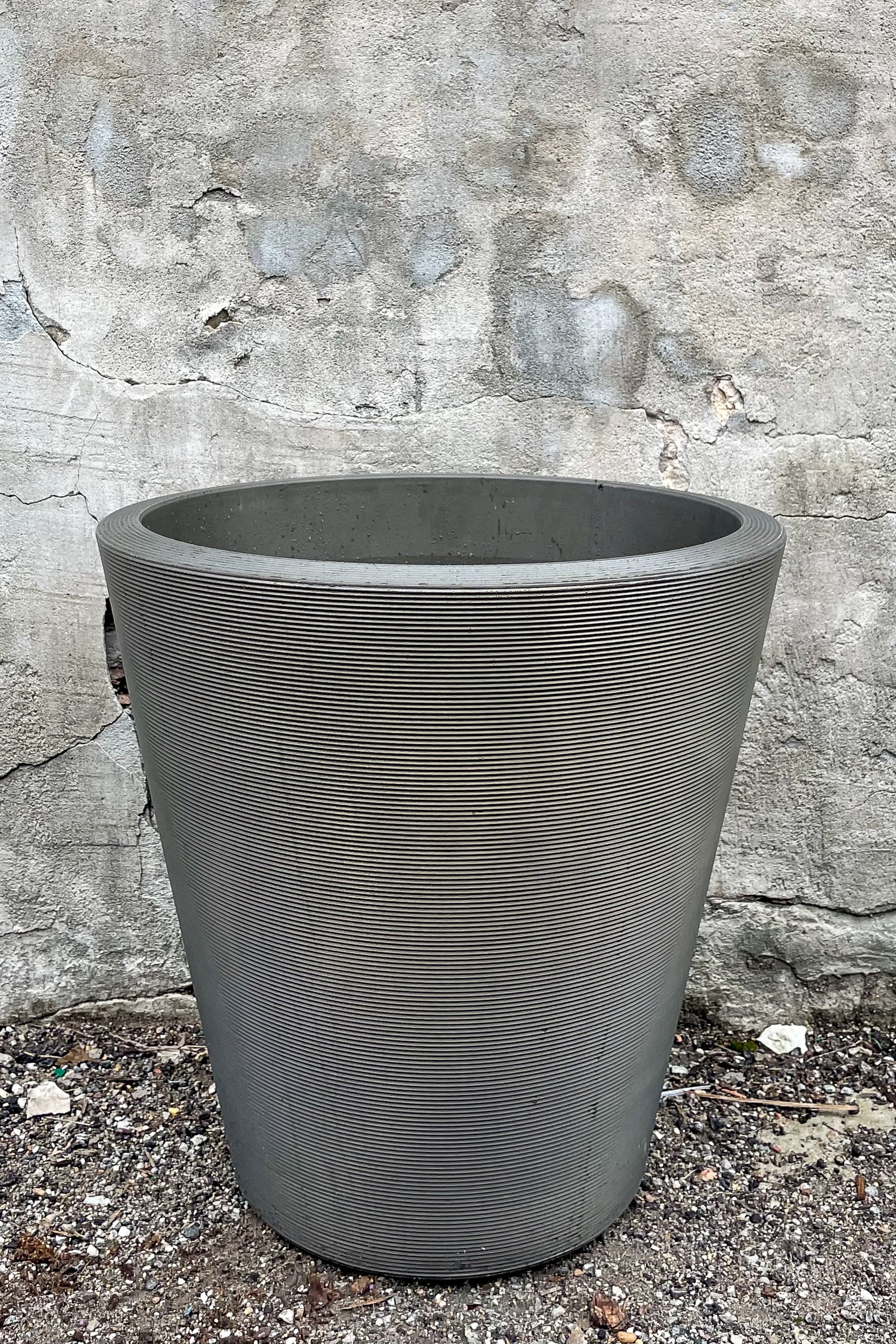 Madison Old Bronze Planter 20" by Crescent Trading in front of concrete wall