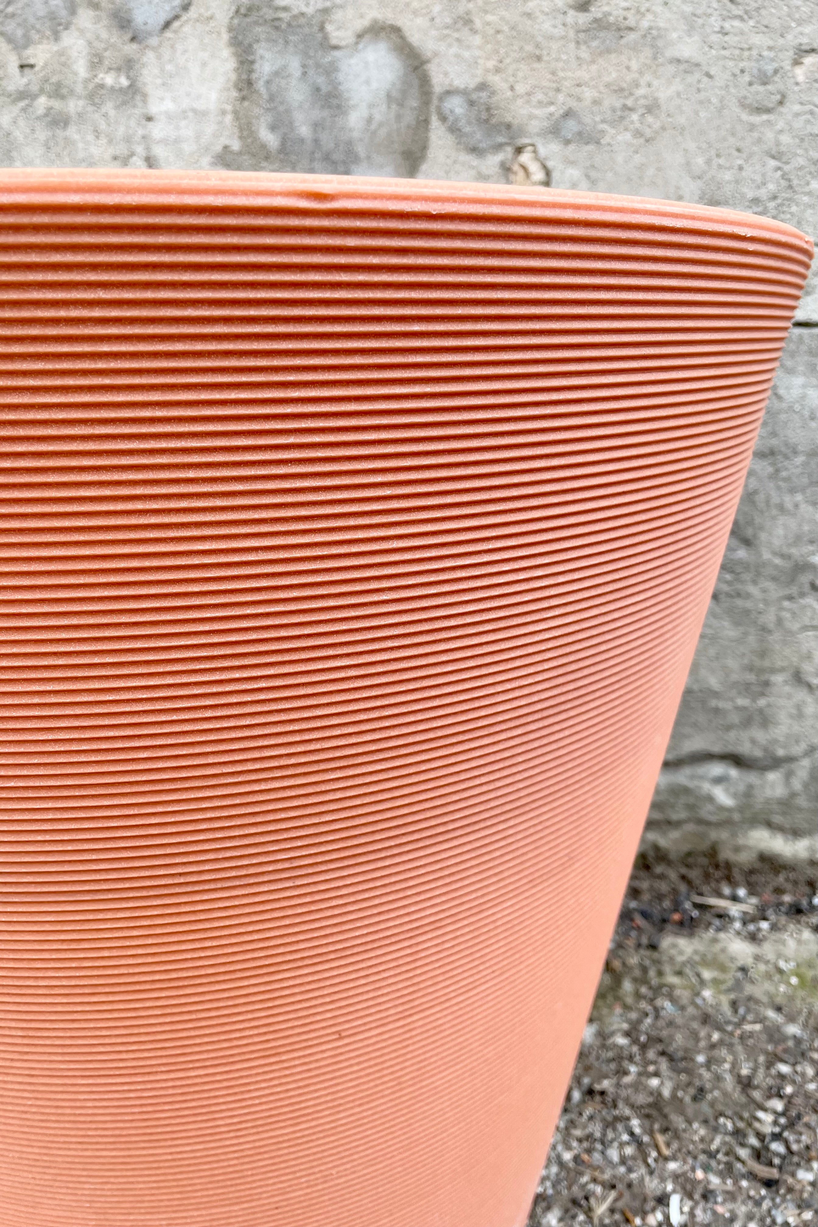 A detailed pictured of the horizontal ridges of the weathered terracotta madison container. 